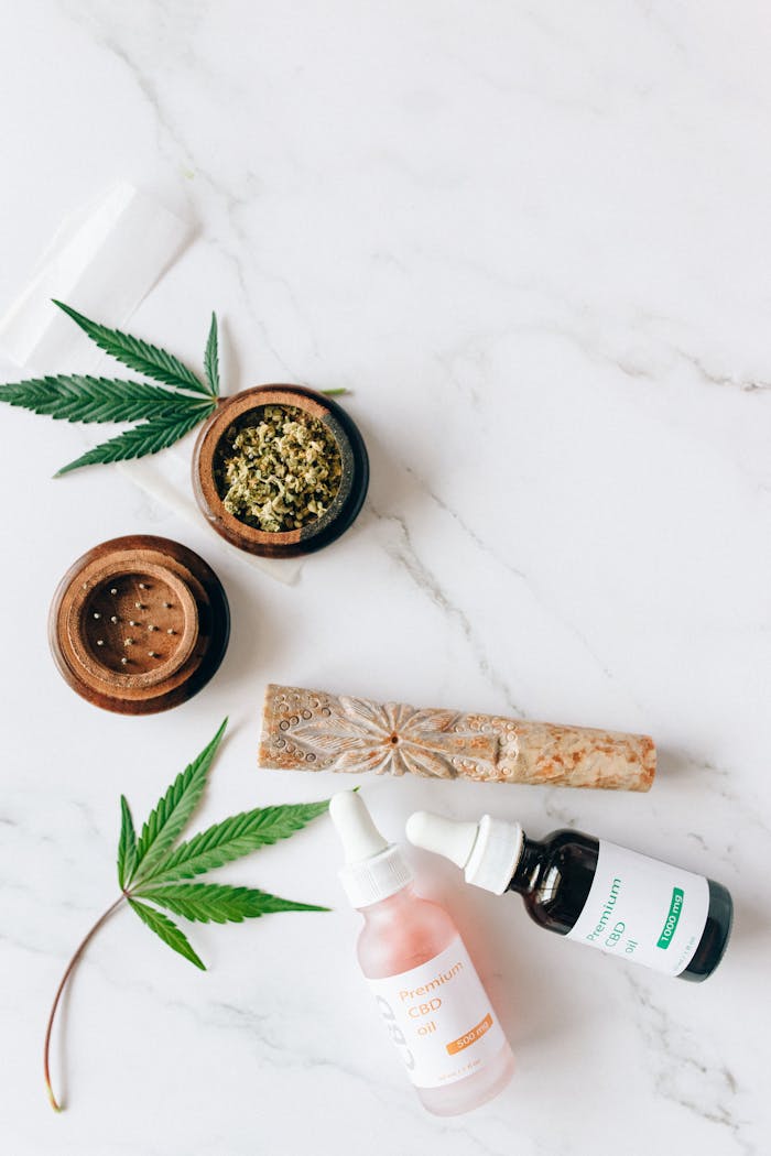 Crafting Captivating Headlines: Your awesome post title goes here Flat lay of CBD oils, cannabis leaves, and grinder on a marble background.