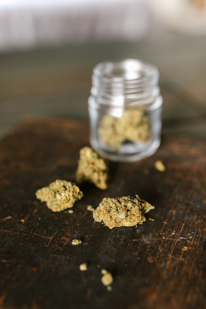 Home Close-up of cannabis buds spilling from a jar, emphasizing legal use.